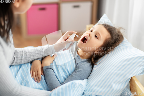 Image of mother with oral spray treats sick little daughter