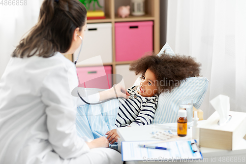 Image of doctor with stethoscope and sick girl in bed