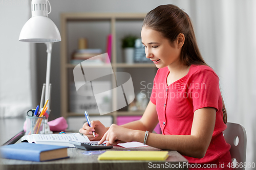 Image of student girl counting on calculator at home