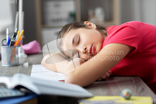 Image of tired student girl sleeping on table at home