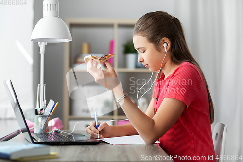 Image of student girl in earphones with pizza at home