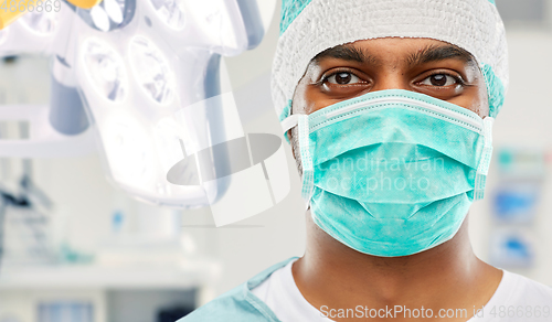 Image of indian male surgeon in mask over operating room