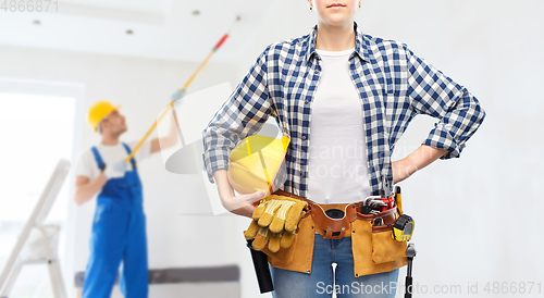 Image of woman or builder with helmet and working tools