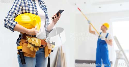 Image of woman or builder with phone and working tools