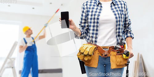 Image of woman or builder with phone and working tools