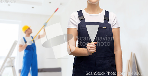 Image of close up of female builder with putty knife