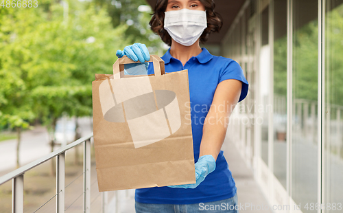 Image of delivery woman in face mask with paper bag