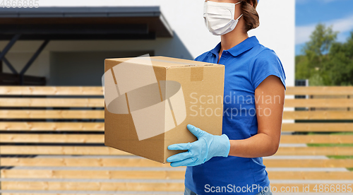 Image of delivery woman in face mask holding parcel box