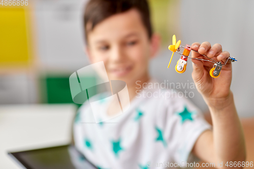 Image of happy little boy playing with airplane toy at home