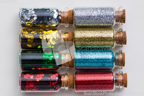 Image of set of glitters in bottles over white background