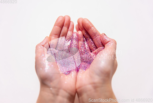 Image of hands holding glitters on white background