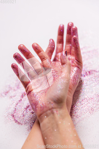 Image of hands with glitters on white background