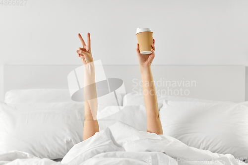 Image of woman with coffee lying in bed showing peace