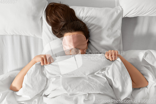 Image of woman with eye sleeping mask in bed under blanket