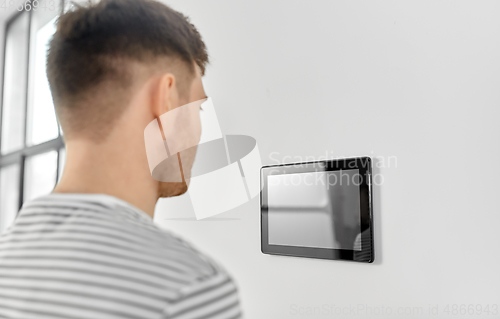 Image of man looking at tablet computer at smart home