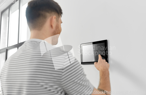 Image of man looking at tablet computer at smart home