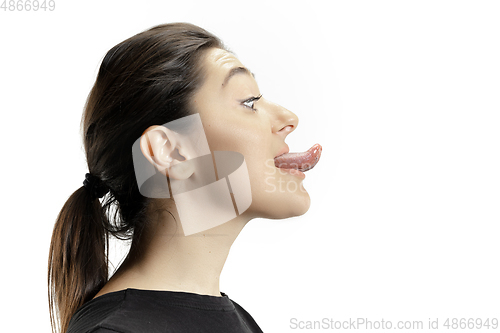 Image of Smiling girl opening her mouth and showing the long big giant tongue isolated on white background, crazy and attracted