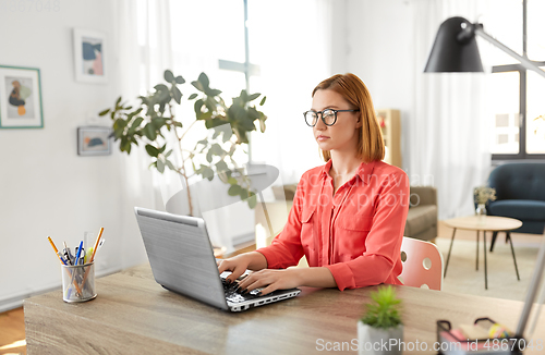 Image of woman with laptop working at home office