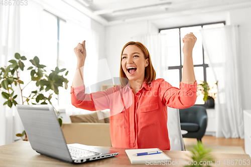 Image of happy woman with laptop working at home office