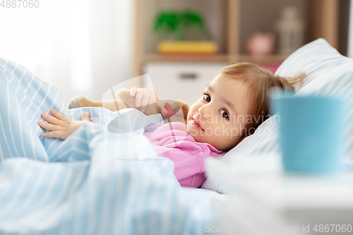 Image of little girl lying in bed at home