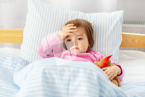 Image of sick little girl lying in bed at home