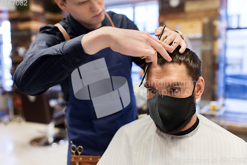 Image of man and barber cutting hair at barbershop