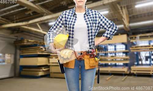 Image of female worker with helmet and tools at factory