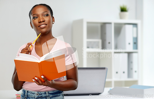 Image of african american woman with notebook at office