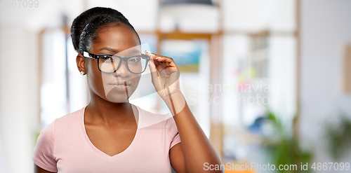 Image of african american woman in glasses over office