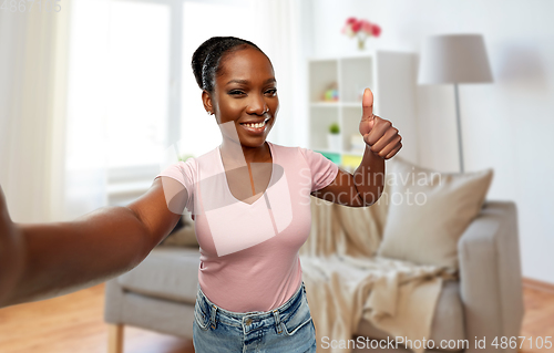 Image of african woman taking selfie and showing thumbs up