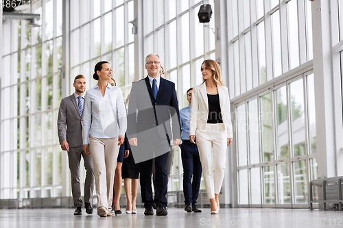 Image of business people walking along office building