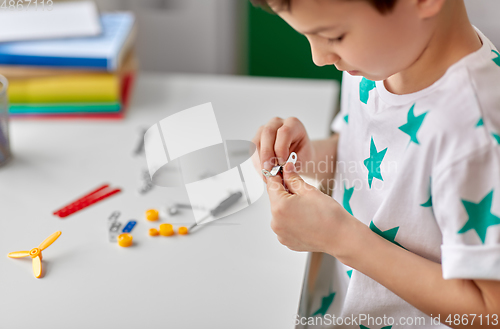 Image of happy little boy playing with airplane toy at home