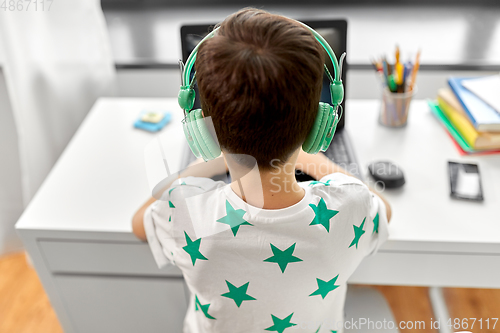 Image of boy in headphones playing video game on laptop