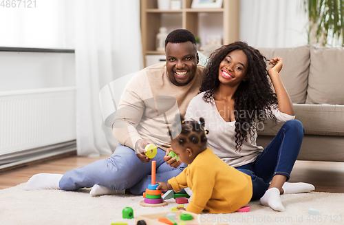 Image of african family playing with baby daughter at home