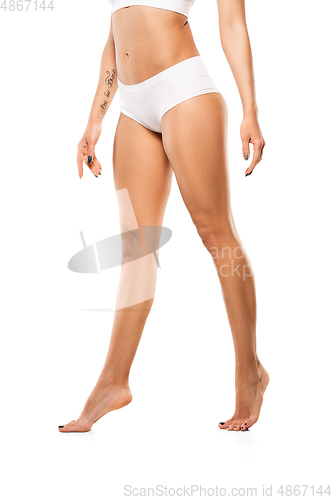 Image of Beautiful female legs and belly isolated on white background. Beauty, cosmetics, spa, depilation, treatment and fitness concept, sensual posing