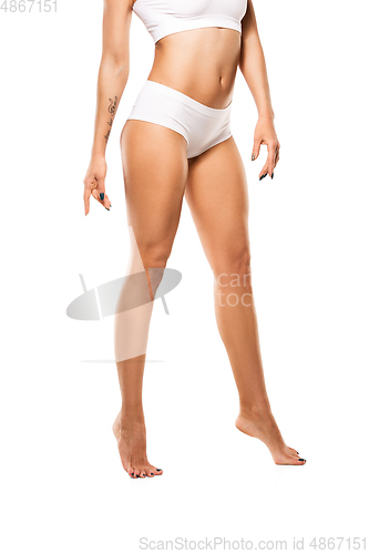 Image of Beautiful female legs and belly isolated on white background. Beauty, cosmetics, spa, depilation, treatment and fitness concept, sensual posing