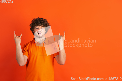 Image of Caucasian young man\'s monochrome portrait on orange studio background