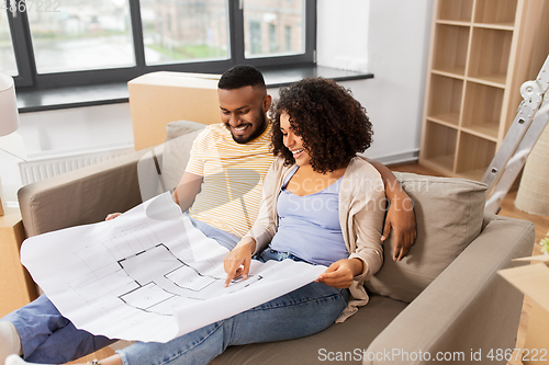 Image of couple with boxes and blueprint moving to new home