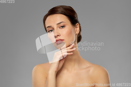 Image of beautiful young woman touching her face and chin