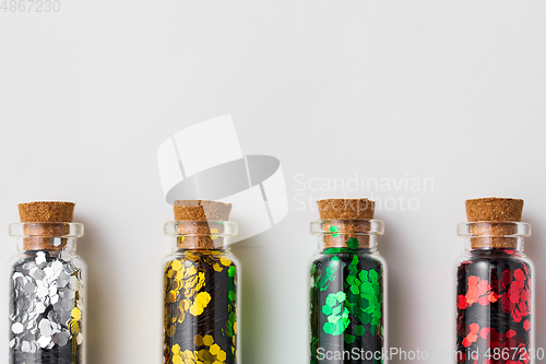 Image of set of glitters in bottles over white background