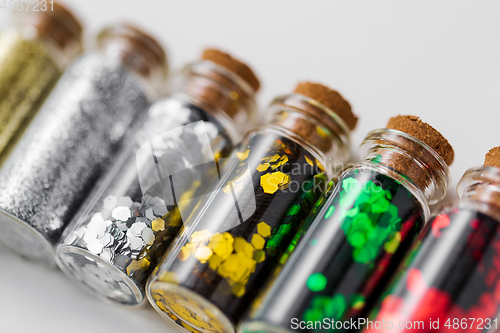 Image of set of glitters in bottles over white background