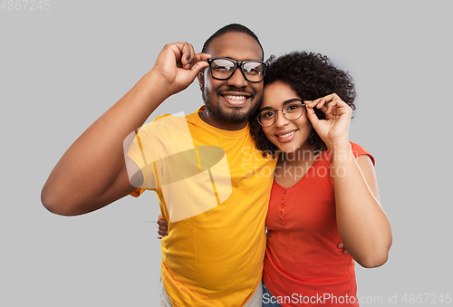 Image of happy african american couple in glasses hugging