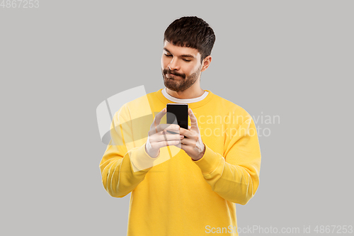 Image of puzzled young man with smartphone