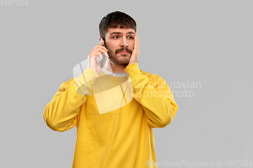 Image of sad young man calling on smartphone