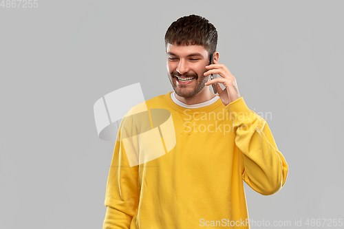 Image of happy smiling young man calling on smartphone