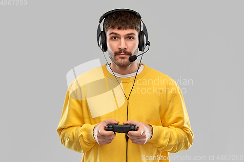 Image of man with headset and gamepad playing video game
