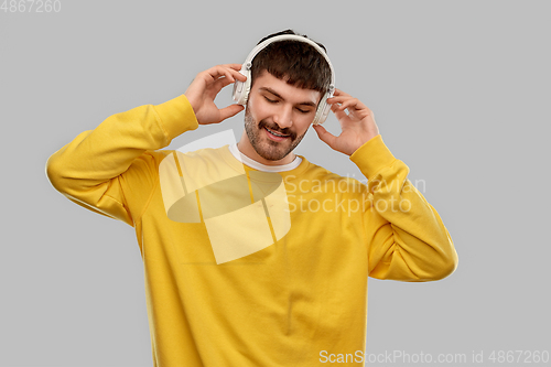 Image of happy young man in headphones listening to music