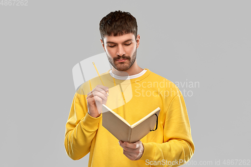 Image of thinking man with diary and pencil