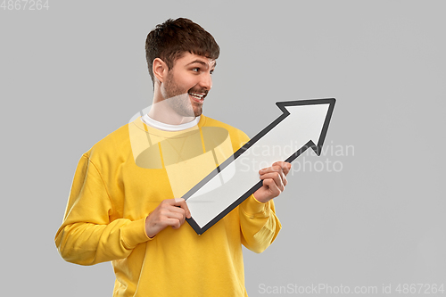 Image of smiling man holding big arrow pointing to right