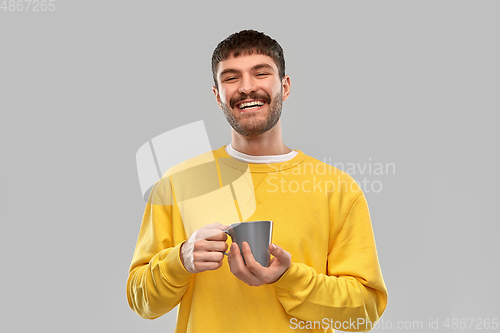 Image of happy smiling young man with coffee cup